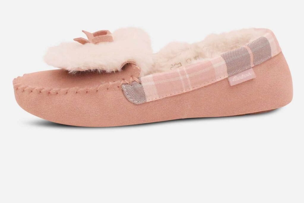 Pink moccasin slipper with a plaid accent and fluffy bow, designed for warmth and a feminine touch.